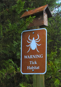 A sign warns us to be aware of ticks in the bee yard.