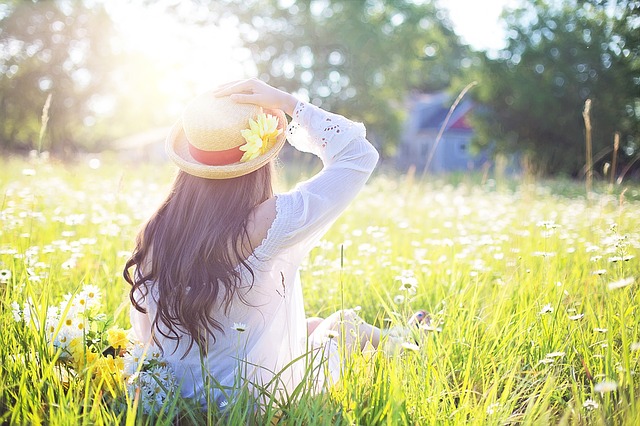 A young girl sitting in a meadow as the sun rises. Beekeeping will change you.